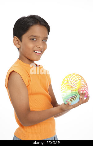 Ten year old boy playing with colourful magic spring MR#703V Stock Photo