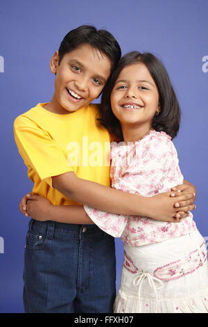 Ten and eight year old boy and girl standing and holding each other MR#703U,703V Stock Photo