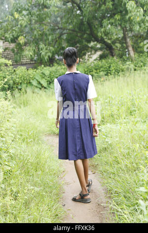 School going girl walking on pathway , Maharashtra , India MR#703Z Stock Photo