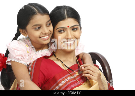 Indian farmer daughter standing behind mother MR#743B,743C Stock Photo