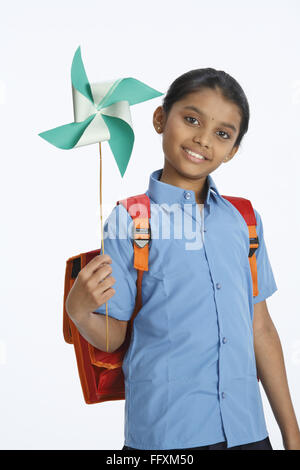 Rural girl carrying school bag on shoulder holding whirligig in left hands MR#743C Stock Photo