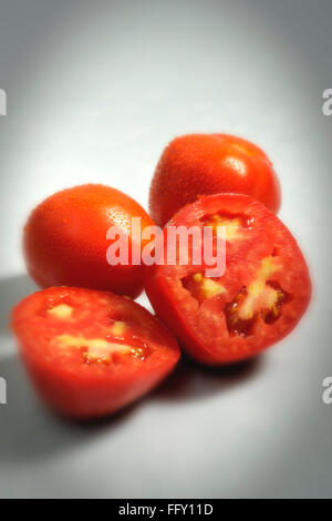 Vegetables , water drops on full and half cut tomatoes on white background Stock Photo