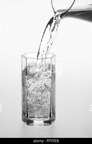 Pouring water in transparent crystal glass Stock Photo