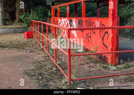 Red painted metal fence showing people where to queue Stock Photo