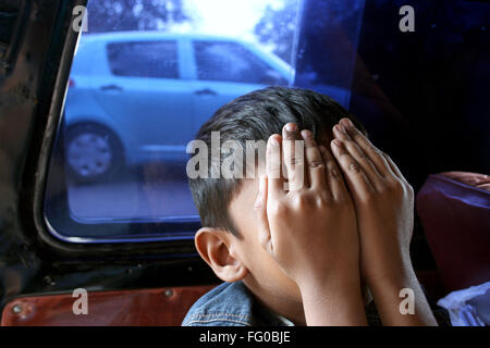 A boy covering face with hands Stock Photo