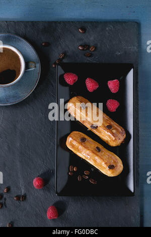 Coffe eclair with raspberries Stock Photo
