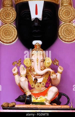 Richly decorated idol of lord Ganesh elephant headed god sitting mouse Ganpati festival Guruji Talim Mandal Pune Maharashtra Stock Photo