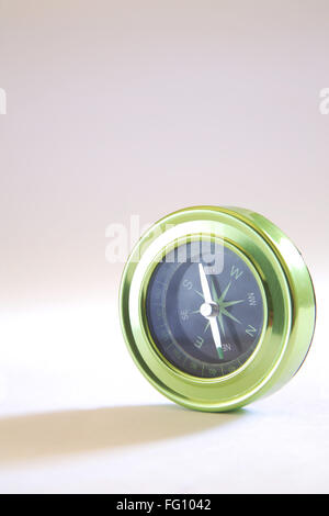 Compass instrument with magnetic needle indicating east north south west on white background Stock Photo