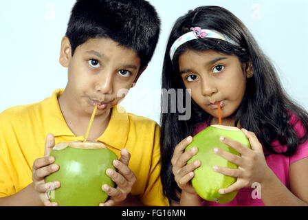 South Asian Indian boy and girl drinking coconut water with straw MR#152 Stock Photo