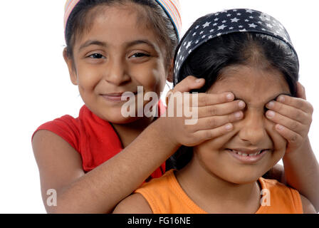 South Asian Indian two sister playing game hide and seek looking at camera MR#152,364 Stock Photo