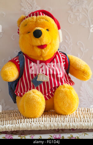 Winnie the Pooh bear soft cuddly toy sitting on wicker basket Stock Photo