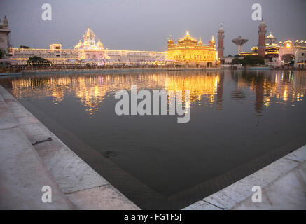 Illuminated Harimandir Sahib swarn mandir or golden temple reflection in pond , Amritsar , Punjab , India Stock Photo