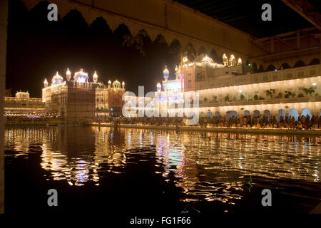 Illuminated Harimandir Sahib swarn mandir or golden temple reflection in pond , Amritsar , Punjab , India Stock Photo