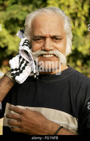 Elderly gentleman wiping perspiration from face with white and black striped napkin MR#671 Stock Photo