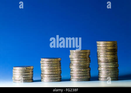 Concept , growth Indian five rupees coins arrange in stack on blue white background Stock Photo