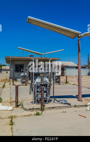 Ruined remains of a gasoline station in the Central Valley of California with stripped down pumps and empty building. Stock Photo