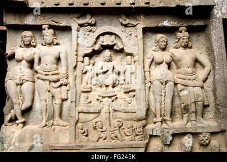 Buddha in centre and two couples carved in stone on front wall of Karla rock cut cave Chaitya hills Lonavala Maharashtra India - stp 209781 Stock Photo