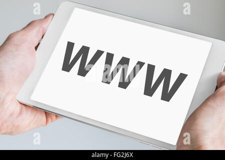 WWW (world wide web) text displayed on touch screen of modern tablet. Hands holding white mobile device Stock Photo