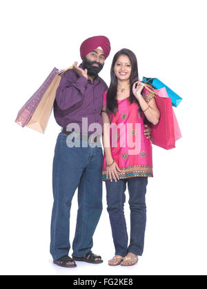 Sikh man and woman holding colourful shopping bags standing close to each other MR#702Z;779A Stock Photo