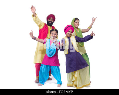 Sikh family performing dancing folk dance bhangra father mother son daughter husband wife brother sister white background India MR#702X;702Y;702Z;779A Stock Photo