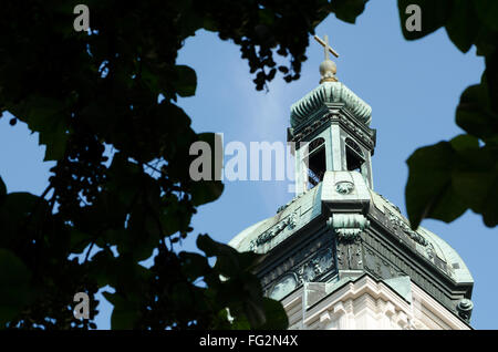 Ornate Church Tower Closeup with Dark Leaves Stock Photo