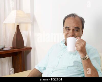 Old man showing white mug MR#702T Stock Photo