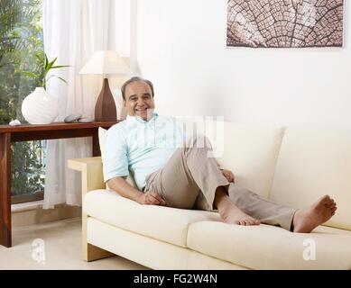 Old man relaxing on sofa MR#702T Stock Photo