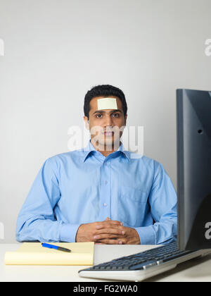 Executive with sticky note on forehead MR#779K Stock Photo