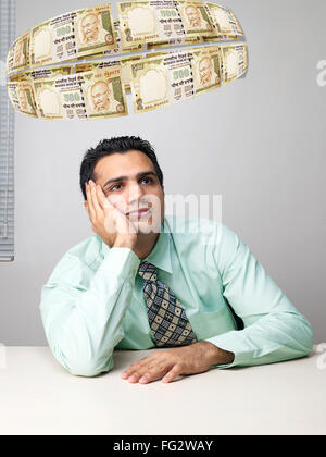 Executive thinking surrounded by flying money MR#779K Stock Photo