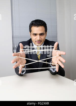 Executive making cats cradle with string MR#779K Stock Photo