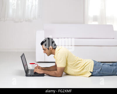 Man laying on floor using laptop MR#779K Stock Photo