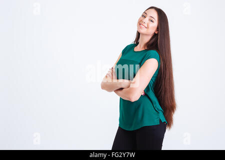Cheerful beautiful young woman with dark long hair standing and posing over white background Stock Photo
