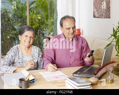 Old couple preparing legal document operating mobile MR#702T,702S Stock Photo