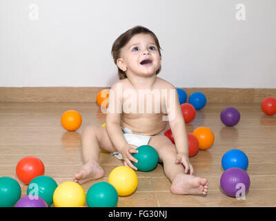 Baby playing with colourful balls ; MR#779N Stock Photo