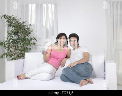 Couple embracing using remote control ; MR#779L  ; MR#779M Stock Photo