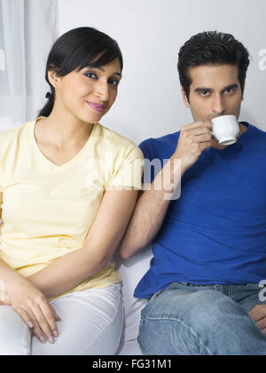 Woman sitting while man holding a cup MR#779L ; MR#779M Stock Photo