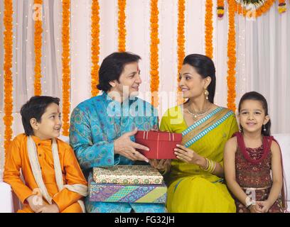 Couple exchanging presents with children MR#779P ; MR#779Q ; MR#779R ; MR#779S Stock Photo
