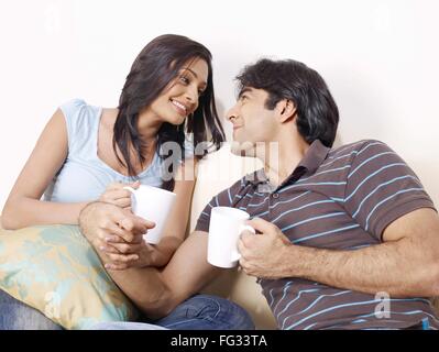 Young man and woman holding hands looking at each other MR#702V,702U Stock Photo