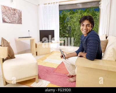 Young man holding remote control looking at camera MR#702V Stock Photo