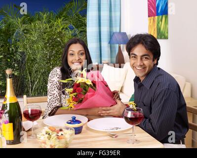 man proposing woman flower bouquet, couple celebrating, husband wife celebration, boyfriend girlfriend, MR#702V,702U Stock Photo