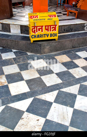 Yellow charity box of ancient Ganga temple on Bank of river Ganga ; Haridwar ; Uttaranchal Uttarakhand ; India Stock Photo