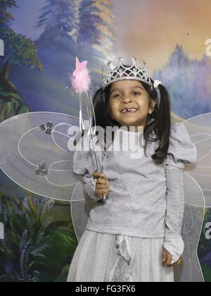 South Asian Indian girl dressed as fairy performing fancy dress competition on stage in nursery school MR Stock Photo