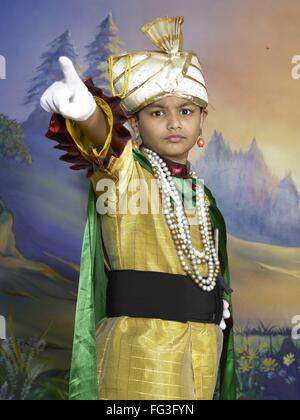 South Asian Indian boy dressed as prince performing fancy dress competition on stage in nursery school MR Stock Photo