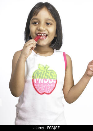 South Asian Indian girl sucking lollipop in nursery school MR Stock