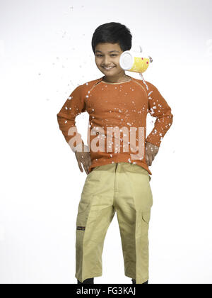 Water pouring on South Asian Indian boy in nursery school MR Stock Photo