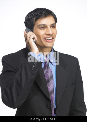 South Asian Indian executive man talking on mobile phone MR Stock Photo