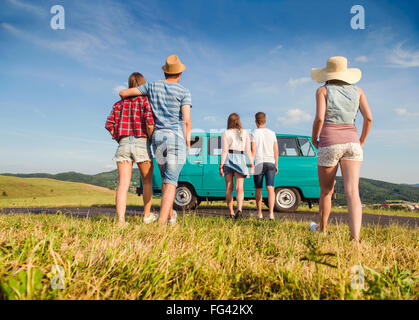 Couples in love, nature, blue sky, campervan, back view Stock Photo