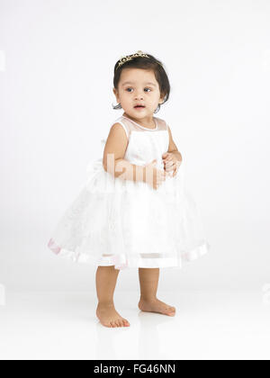 Joyful Indian baby girl wearing white dress MR#702O Stock Photo