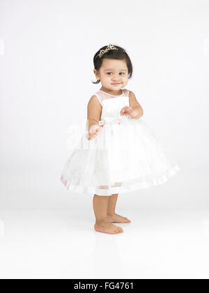 Joyful Indian baby girl wearing white dress MR#702O Stock Photo