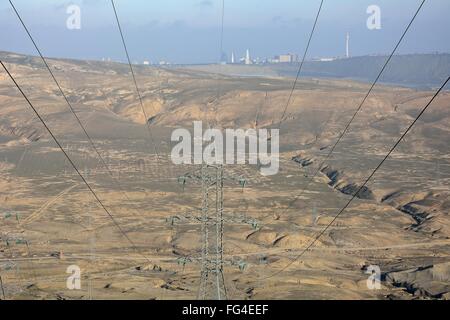 Pylons and cables supplying electricity to Baku, capital of Azerbaijan. A distant Baku can be seen, with lines of high voltage Stock Photo